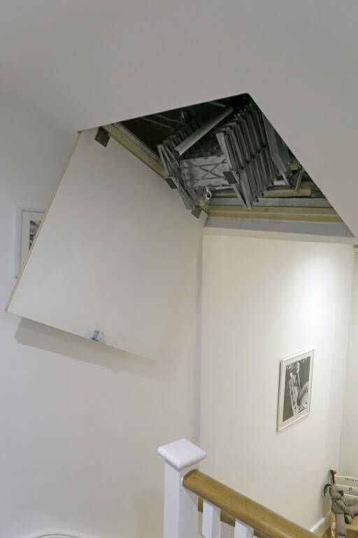 Elite loft ladder fitted behind an angled loft hatch in a sloping ceiling Elite loft ladder fitted behind an angled loft hatch in a sloping ceiling